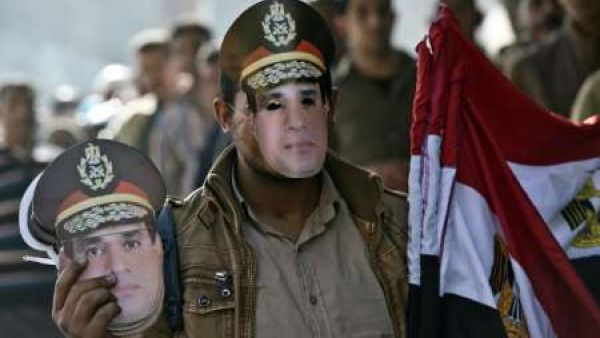 An Egyptian street vendor sells the country's national flag and masks of Egypt's, then Defence Minister but now current president, General Abdel Fattah al-Sisi. (AFP/File)
