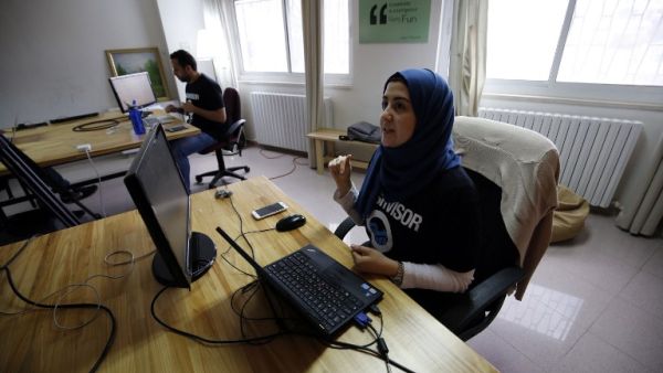 Palestinians work at the office of Red Crow, a startup that monitors security developments and sends real-time alerts to clients. (AFP/Abbas Momani)