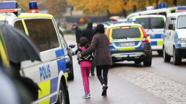A pupil and her parent leaves a primary and middle school in Sweden where a masked man armed with a sword assaulted teachers and students. (AFP/File)