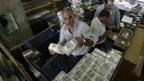 A banker stacks packed Syrian lira bills at the Central Bank in Damascus in 2011. (AFP/File) 