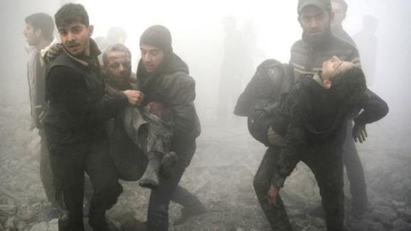 Syrian men carry injured victims following a reported airstrike on the besieged rebel-held town of Douma on Jan. 21, 2015. (AFP/Sameer al-Doumy) 