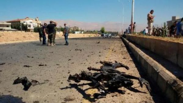 جنود بالجيش السوري ومدنيون في موقع تفجير يوم الاثنين
