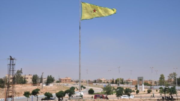 علم وحدات حماية الشعب الكردية مرفوعا في بلدة تل ابيض السورية
