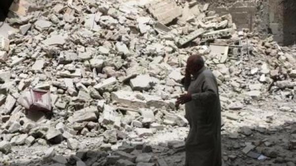 رجل يسير وسط حطام مبنى دمر بعد غارة جوية على حلب
