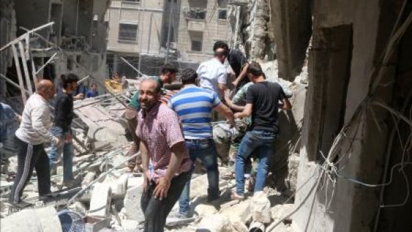 رجال في موقع تعرض لقصف في منطقة خاضعة لسيطرة المعارضة في حلب
