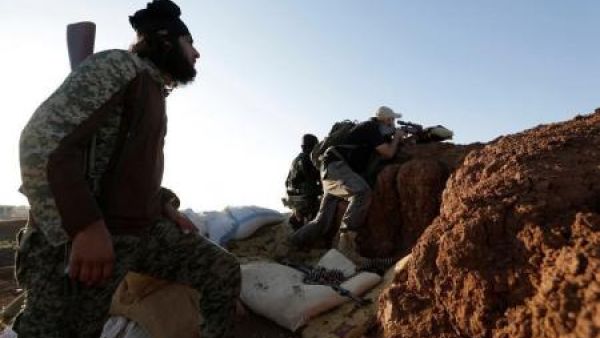 مقاتل من "جيش السنة" يقف عند نقطة مراقبة في ريف حلب الجنوبي بسوريا
