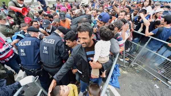 Thousands of migrants wait for their departure to Germany at the Austrian side of the Hungarian-Austrian border in Heiligenkreuz on September 19, 2015. (AFP/Attila Kisbenedek) Thousands of migrants wait for their departure to Germany at the Austrian side of the Hungarian-Austrian border in Heiligenkreuz on September 19, 2015. (AFP/Attila Kisbenedek)