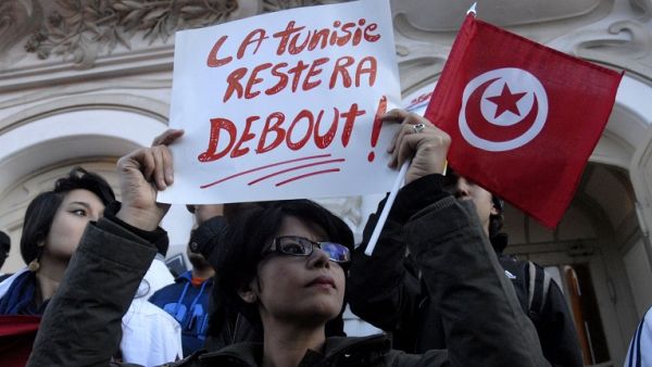 A Tunisian woman holds a placard reading in French "Tunisia will remain standing" as she takes part in a protest on March 18, 2015 after an attack on the Bardo National Museum in Tunis. (Sofiene Hamdaoui/ AFP)