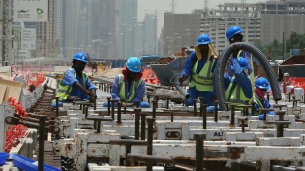 Foreign laborers work outside at the construction site of a track for the Dubai Metro, on 22 May 2013. (AFP/ Marwan Naamani)