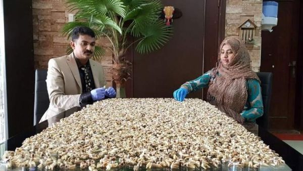 Dr. Nizar Abdul Rahman and his wife pose with their collection of some 10,000 teeth collected over 15 years. (Twitter/Khaleej Times)