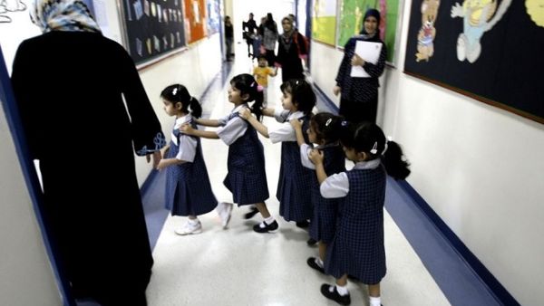 Students line up as they enter their classroom on the first day of the academic year for public schools in Dubai on September 27, 2009. (Karim Sahib/ AFP)