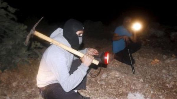 فلسطينيان يشاركان في حراسة قريتهم ليلا بالضفة الغربية
