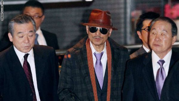 كينيشي شينودا (الوسط) زعيم أكبر الجماعات الإجرامية اليابانية ياماغوشي غومي، بعد الإفراج عنه من السجن عام 2011
