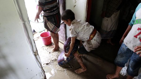 A boy helps clear the floodwaters from his home in Sanaa, Yemen. (AFP/Mohammed Huwais)