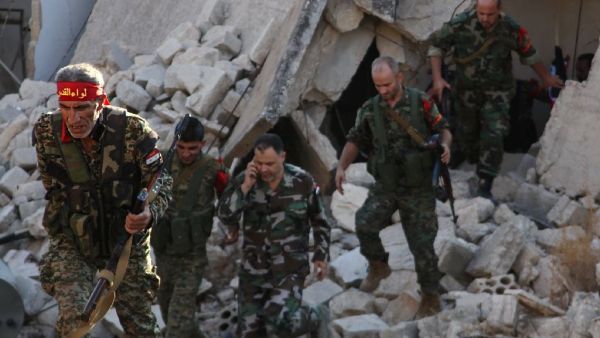 Syrian pro-government soldiers patrol the Uwaija neighborhood as they advance in Aleppo's rebel-held areas. (AFP/George Ourfalian)