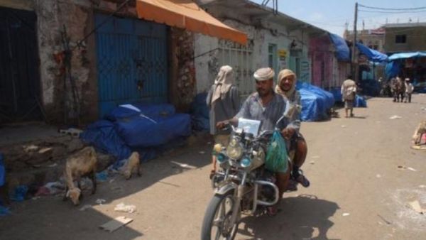 يمنيان يستقلان دراجة نارية في صنعاء 
