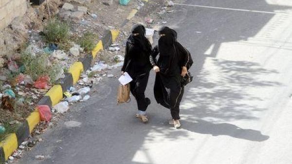 يمنيتان تجريان مبتعدتين عن منطقة تضم مخزنا للاسلحة في اليمن خلال تعرضه للقصف
