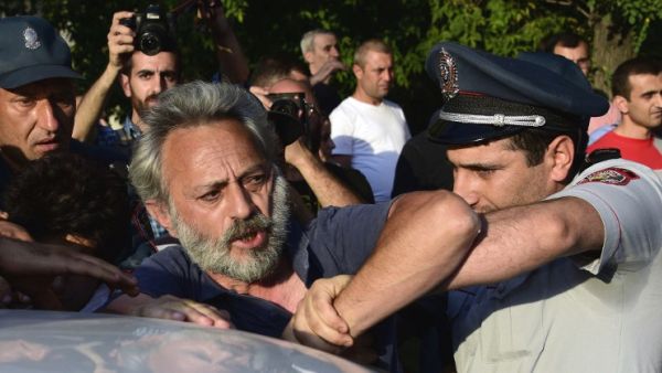 Armenian police detain an opposition supporter, artist Nikol Aghababyan, next to a police check point blocking the streets to Erebuni police station in Yerevan on July 17, 2016. (AFP/Karen Minasyan) Armenian police detain an opposition supporter, artist Nikol Aghababyan, next to a police check point blocking the streets to Erebuni police station in Yerevan on July 17, 2016. (AFP/Karen Minasyan)
