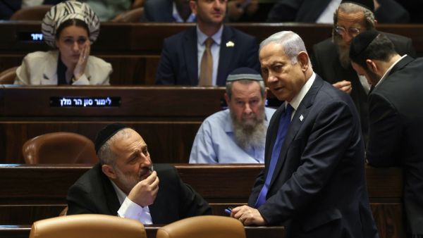 Israel's Prime Minister Benjamin Netanyahu (R) speaks with Aryeh Deri (L), chairman of the ultra-Orthodox party Shas, during a parliament session in Jerusalem on July 24, 2023 - Photo by RONALDO SCHEMIDT / AFP Israeli stocks, shekel drop on Knesset passing judicial overhaul bill