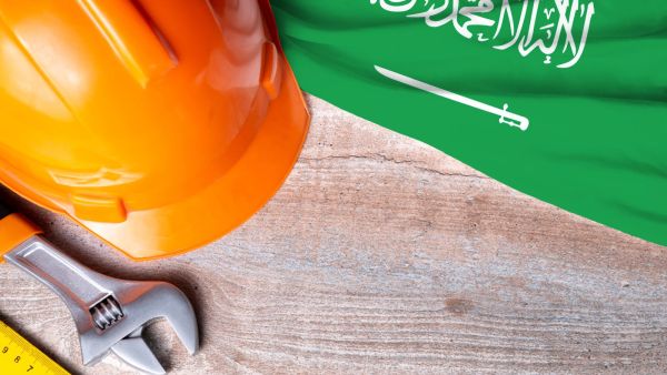 Saudi Arabia flag with different construction tools on wood background - Shutterstock New labor fines in Saudi Arabia