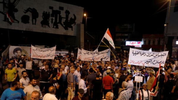 رفع المتظاهرون الذين كان يقودهم اباع التيار الصدري لافتات تندد بالفساد وسوء الخدمات المقدمة للعراقيين