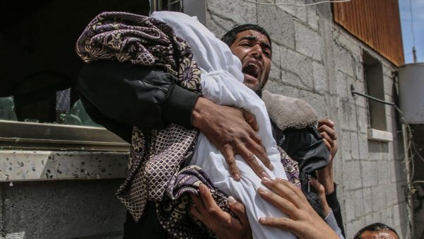 فلسطيني يحمل جثمان قريبة له وهي طفلة في الرابعة عشرة من العمر استشهدت جراء القصف الاسرائيلي