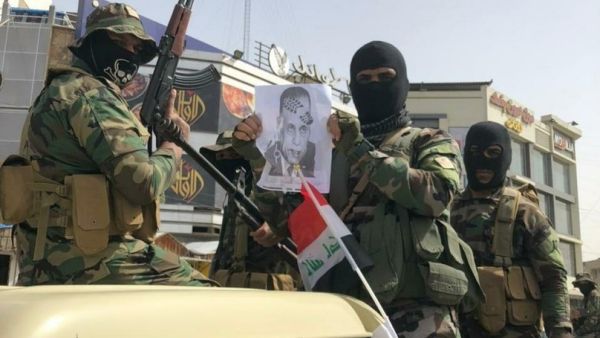 عناصر من مليشيا "ربع الله" يحملون صورة رئيس الحكومة العراقية مصطفى الكاظمي وعليها طبع حذاء