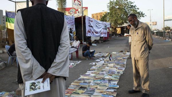 رجل سوداني يستعرض الصحف على احد الارصفة في الخرطوم