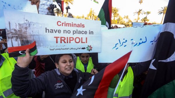 A Libyan youth holds up a protest sign during a demonstration against strongman Khalifa Haftar in the capital Tripoli's Martyrs Square on April 12, 2019.  Mahmud TURKIA / AFP A Libyan youth holds up a protest sign during a demonstration against strongman Khalifa Haftar in the capital Tripoli's Martyrs Square on April 12, 2019.  Mahmud TURKIA / AFP