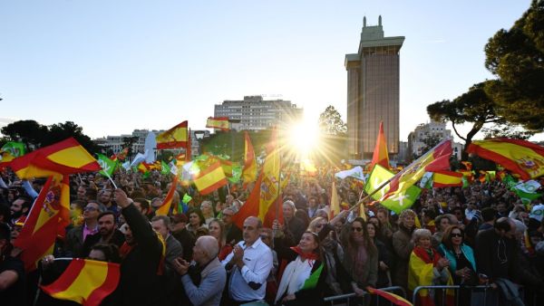Supporters of Spanish far-right party VOX wave flags during the last campaign rally in Madrid (AFP)