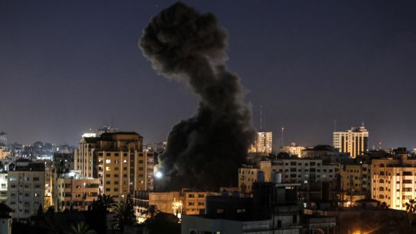 A plume of smoke billows above buildings during an Israeli airstike on Gaza City  (AFP)