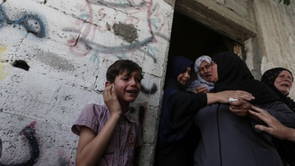 Relatives mourn during the funeral of five Palestinians, who were killed in Israeli strikes (AFP)