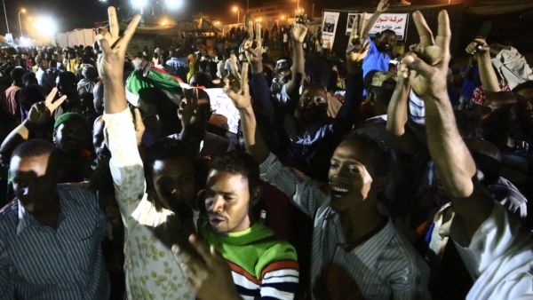 Sudanese protestors celebrate after an agreement was reached with the military council to form a three-year transition period for transferring power to a full civilian administration, in Khartoum (AFP)