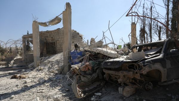 The ruins of a building and the wreckage of a vehicle lie  (AFP)