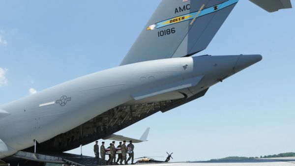 Members of the a U.S. Army carry team move the flag-draped transfer case holding the remains of Army Sgt. James G. Johnston of Trumansburg, New York, off a C-17 transport aircraft during a dignified transfer at Dover Air Force Base  (AFP)
