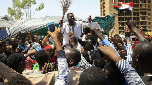 Young Sudanese rally to celebrate after an announcement made by Sudan's new military ruler, outside the army headquarters in the Sudanese capital Khartoum, on April 13 (AFP)