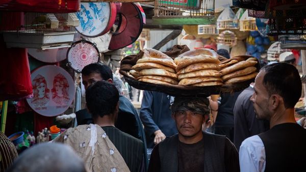 A trader carries a tray of bread on his head through one of the packed local markets in Kabul. Thijs said: 'People are going to their work and trying to get by and not sit around and feel miserable and mope all day about their situation'  (dailymail.co.uk/Thijs Broekkamp)