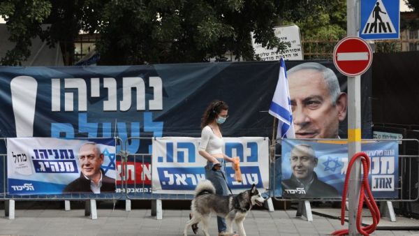 فتاة اسرائيلية امام يافطات الدعاية الانتخابية