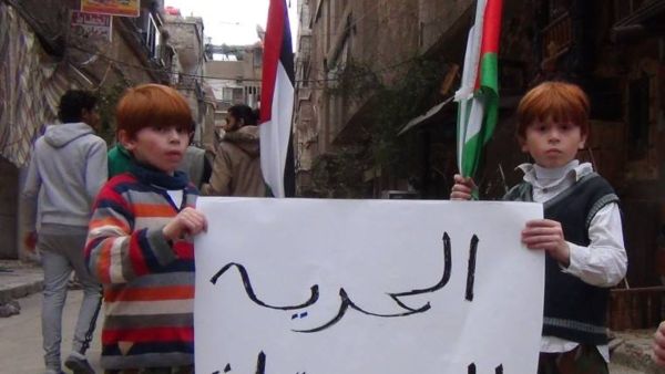 طفلان خلال مسيرة بمخيم اليرموك تطالب بالإفراج عن المعتقلين الفلسطينيين-صورة أرشيفية