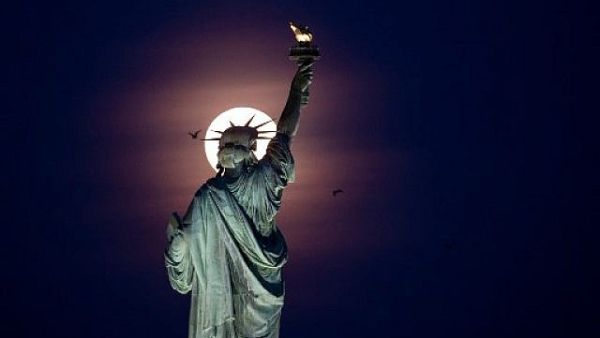 Full moon rises behind the Statue of Liberty in New York City, 2019 /AFP