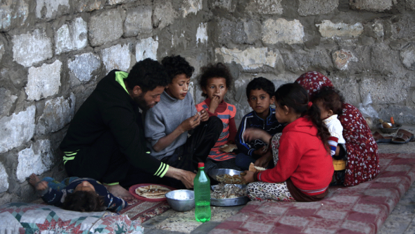 A Palestinian family share an Iftar meal as they break their fast during the Muslim holy fasting month of Ramadan on May 13, 2019 in the southern Gaza Strip refugee camp of Khan Yunis. 