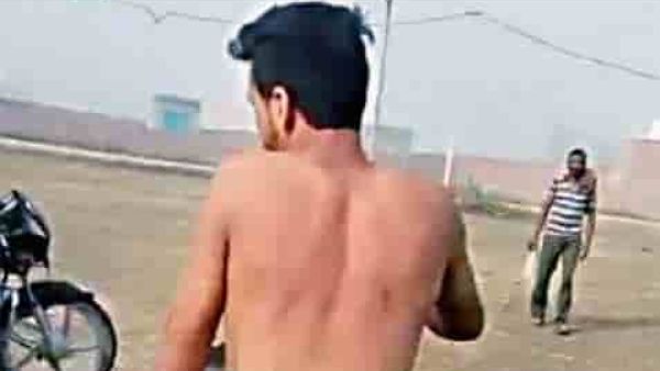 Man stripped naked and forced to ride a motorbike for sexually harassing a woman in India. 