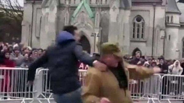 Screenshot of a video showing a young man kicking a person who tries to burn the Holy Quran during an anti-Islam rally in Norway