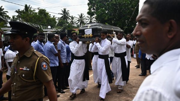 Relatives and priests carry the coffin of a bomb blast victim after a funeral service at St Sebastian's Church in Negombo on April 23, 2019. (AFP)