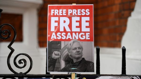 A supporter of WikiLeaks founder Julian Assange holds a placard outside the Ecuadorian Embassy in London on April 5, 2019, following rumours that Assange was about to be expelled. (Daniel LEAL-OLIVAS / AFP)