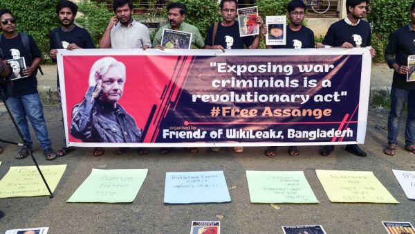 Activists stand behinf a banner and hold placards while forming a human chain calling for the freedom of the international non-profit organisation"WikiLeaks" founder Julian Assange, in Dhaka on April 23, 2019. (AFP)
