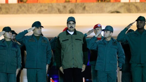 This handout picture released by Miraflores Palace press office shows Venezuela's President Nicolas Maduro (C) receiving the military salute from loyal troops at the "Fuerte Tiuna" in Caracas, Venezuela on May 2, 2019. (AFP)
