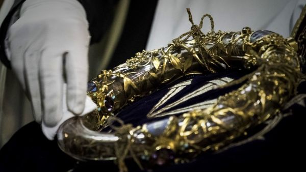 In this file photo taken on April 14, 2017 shows a priest wiping the Crown of Thorns, a relic of the passion of Christ- at the Notre-Dame Cathedral in Paris. Philippe Lopez / AFP