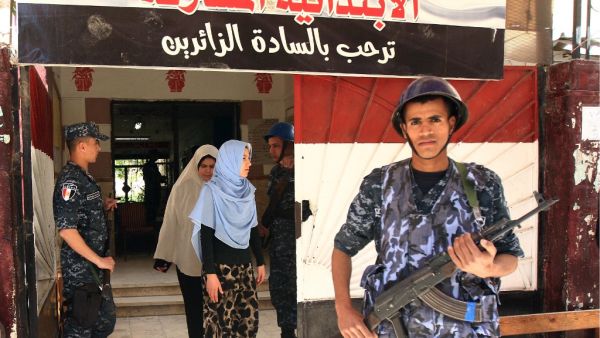 Egyptian security forces stand guard outside a polling station in the Mediterranean port city of Alexandria, where locals were voting in a referendum on constitutional amendments. (AFP/ File Photo)