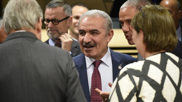 Palestinian Prime Minister Mohammad Shtayeh (C) talks with EU Commissioner for Enlargement Negotiations Johannes Hahn (L). (AFP/ File Photo)